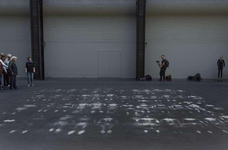 White marks on a black floor in an art gallery