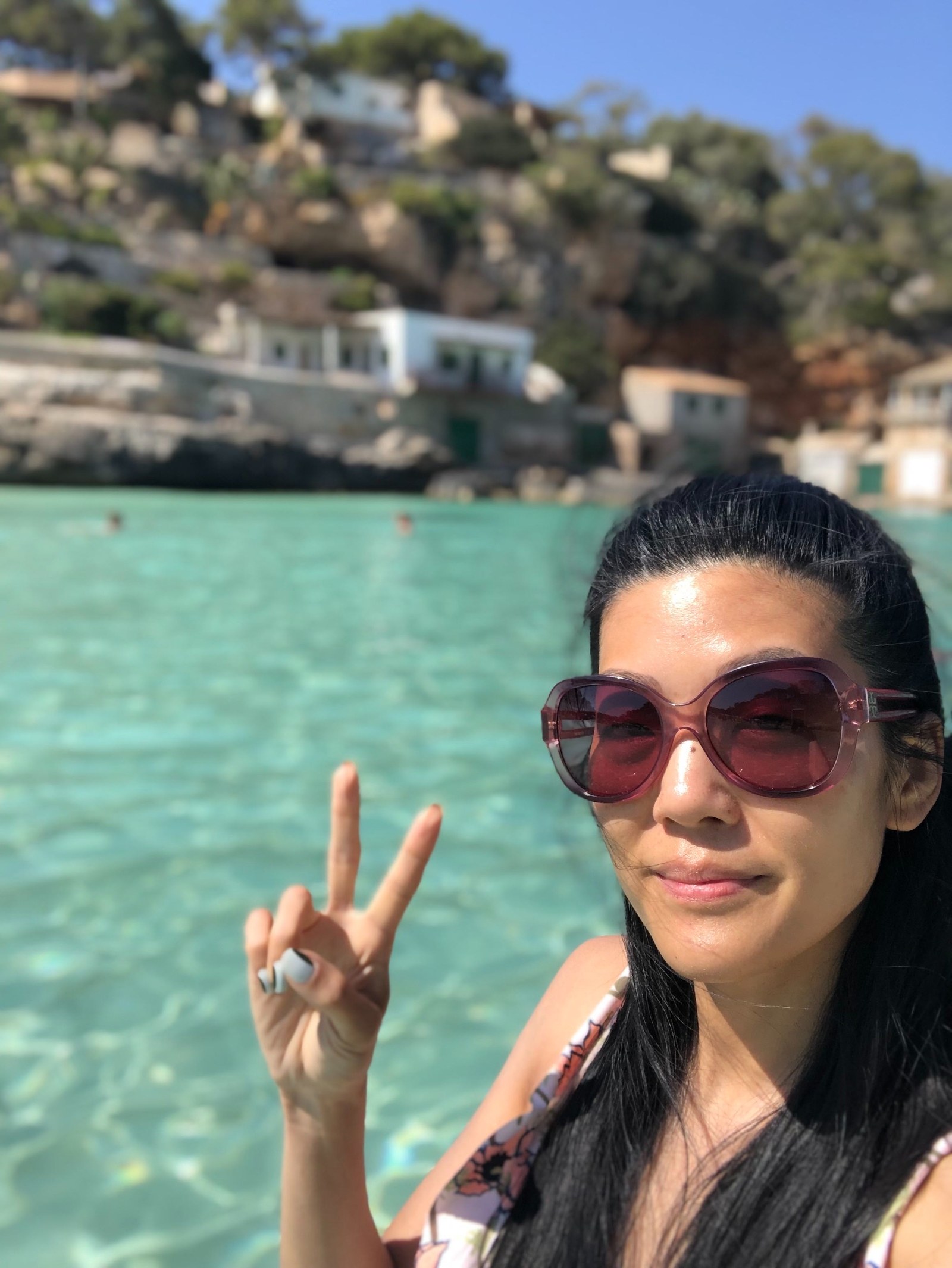 selfie of Michelle Lee with a peace sign in front of a sea