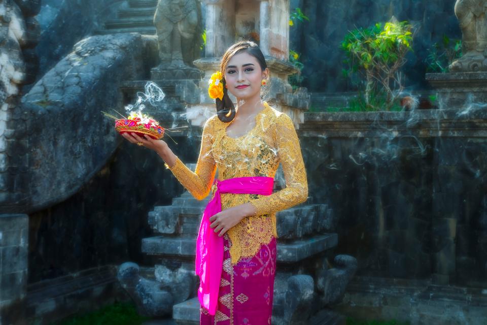 Balinese woman wearing traditional costume with accessories,offering,ornaments in hinduist temple in bali Indonesia