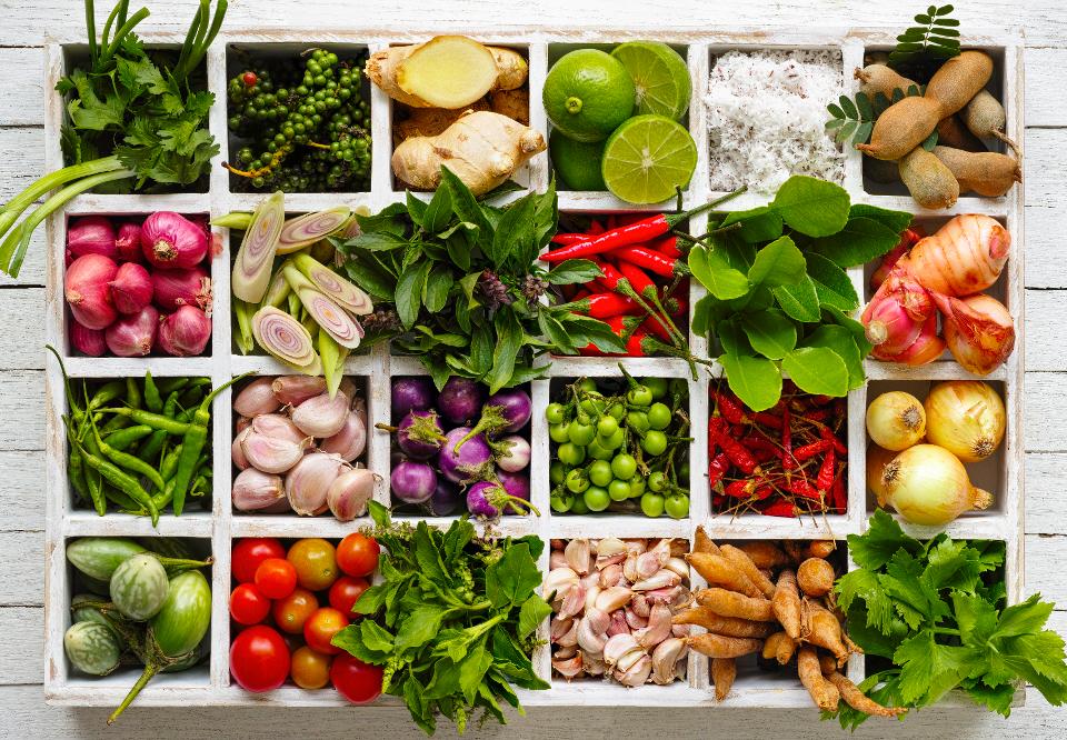 Thai food herbs and spice ingredients in a wooden tray.