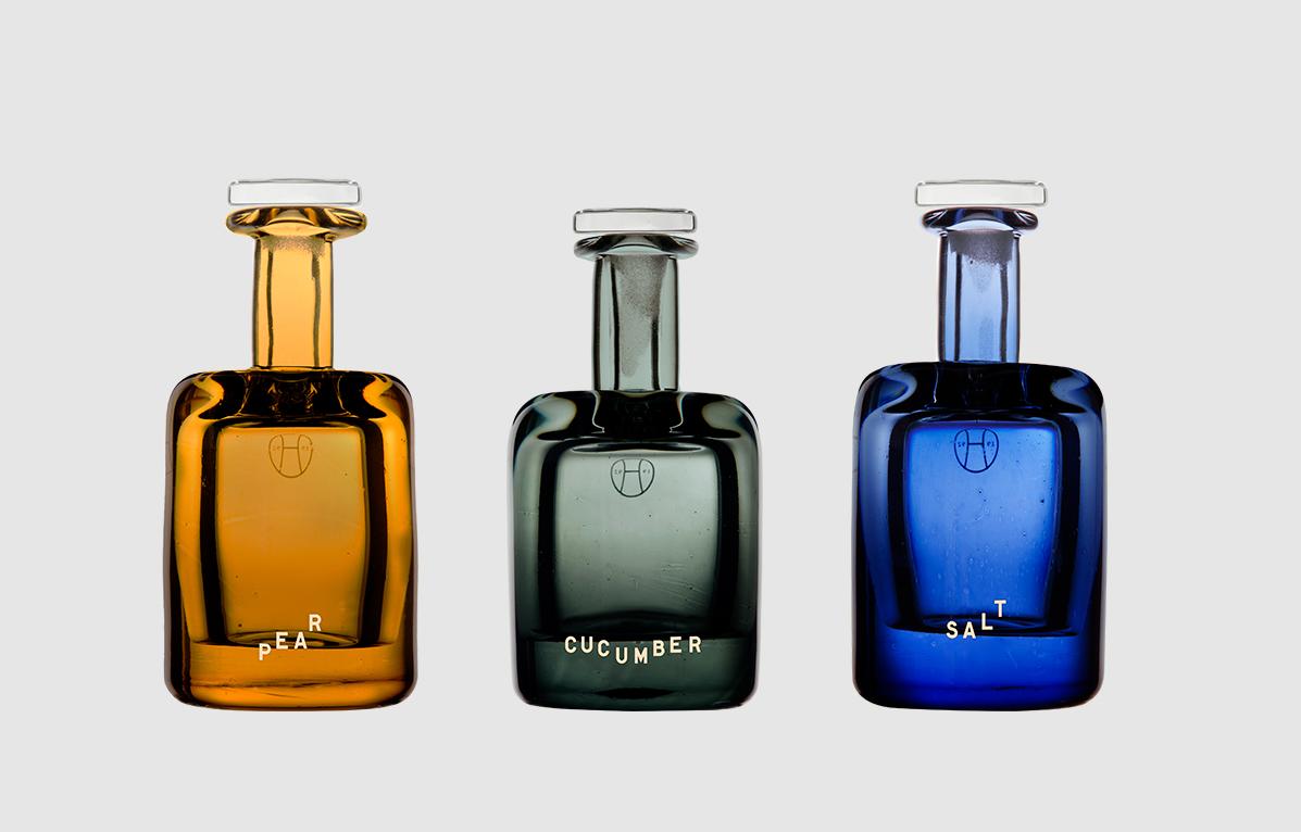 pear perfume in orange glass bottle, cucumber perfume in green bottle, and salt perfume in blue glass bottle