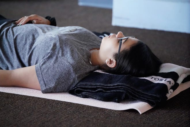 Chloe McGowan, reporting for The IndyStar, takes part in a group sound bath with facilitator Sarah Gardner on Wednesday, July 13, 2022, at the Maven Space social a co-working club in Indianapolis.