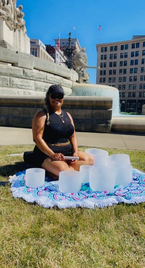 Preciss Stone, a 44-year-old sound bath meditation artists from Indianapolis, plays her singing bowls at the Soldiers and Sailors monument in Downtown Indianapolis.