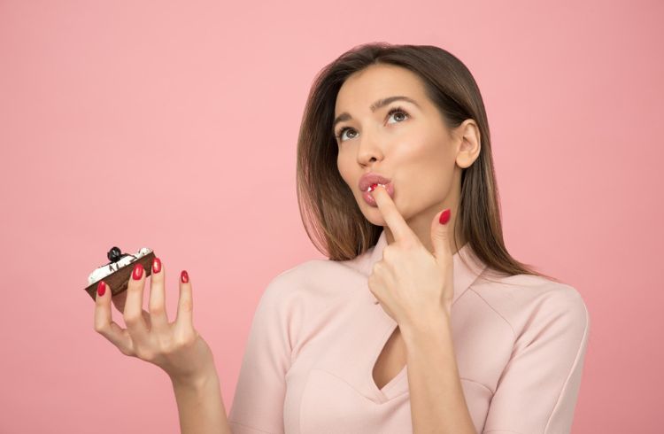 A woman tasting a piece of cake